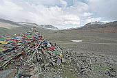 Ladakh - pile of stones on  mountain pass with the characteristc prayer flags 